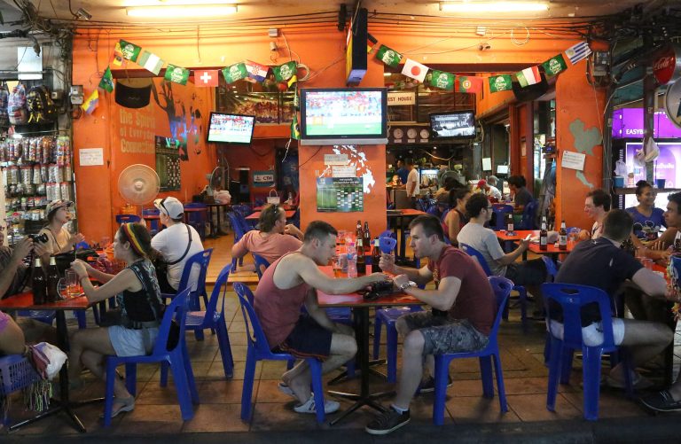 Tourists and locals eat and drink at a restaurant in Bangkok's Khaosan road, Thailand, Saturday June 14, 2014. The generals who seized power in Thailand have lifted a nationwide curfew, giving a green light for the capital's red-light districts, nightclubs and pubs to roar back to life. Late night revelry was planned in Bangkok to celebrate the return of Saturday night freedom for the first time in a month. (AP Photo/Apichart Weerawong)