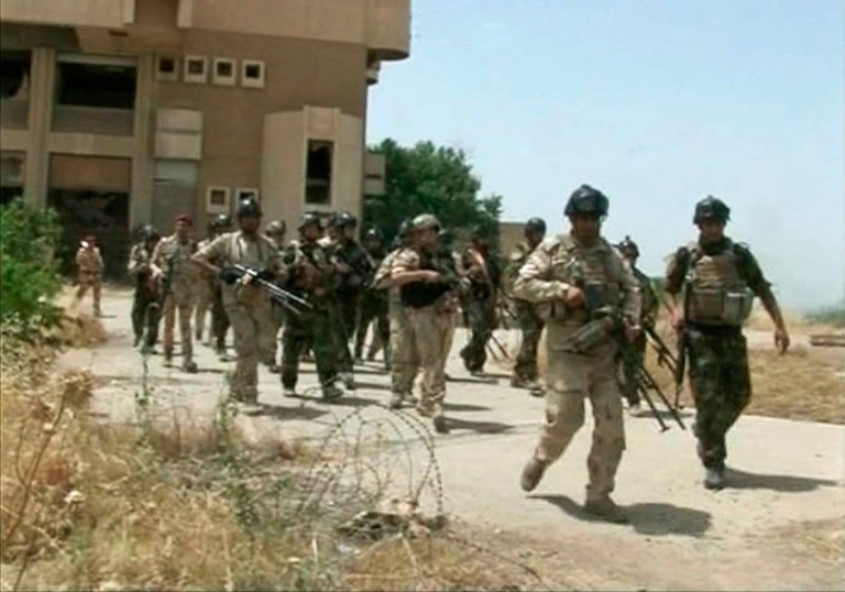 Military soldiers prepare to take their positions during clashes with militants in the northern city of Mosul, Iraq. Insurgents on Tuesday pressed their efforts to seize effective control of Iraq's second-largest city of Mosul on Tuesday after Iraqi security forces abandoned their posts and militants overran the provincial government headquarters and other key buildings, dealing a serious blow to Baghdad's attempts to tame a widening insurgency in the country. (AP Photo/Iraqi Military via AP video)