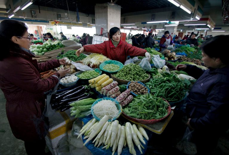  Women buy vegetables from a vendor at a market in Nanjing in east China's Jiangsu province Sunday, Dec. 9, 2012. China's main gauge of inflation rose 2.0 percent in November, up from the previous month's 1.7 percent, driven largely by food price increases, the government said Sunday. (AP Photo) CHINA OUT  