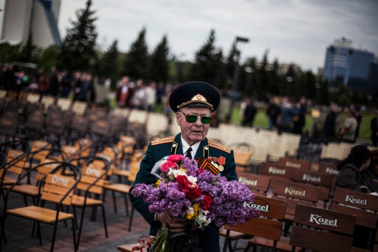 FILE - In this May 9, 2014, file photo, a veteran from the Red Army holds a bouquet of flowers while attending the commemoration of Victory Day in Donetsk, Ukraine. The crisis in Ukraine is giving Russia an opening to drive a wedge between the United States and Europe just as Western powers try to repair a struggling trade deal and decide how to bolster a cash-strapped NATO.  (AP Photo/Manu Brabo, File)