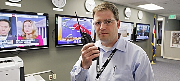 In this photo taken on Wednesday, Sept. 21, 2011, Dana Reynolds, Director of Colorado Information Analysis Center, talks on a radio in the center in Lakewood, Colo. The center processes bits and pieces of information sent by police across the state that normally don't make sense individually. It's one of 50 state centers__plus 20 regional center across the country__that collects such tips and intelligence after the 9/11 attacks. (AP Photo/Ed Andrieski)