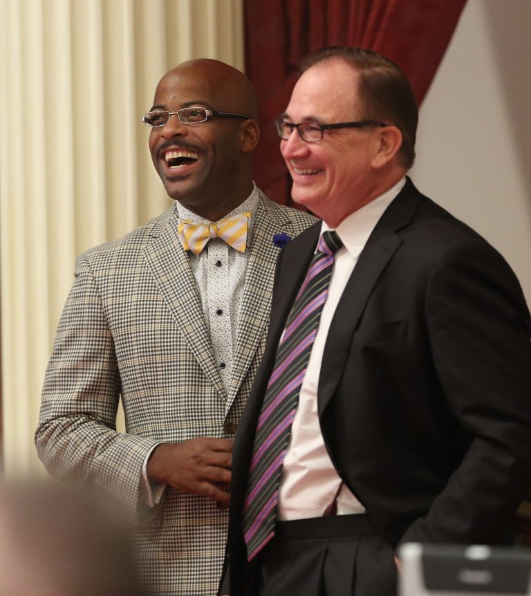 Assemblyman Isadore Hall, Compton, left, and Senate Minority Leader Bob Huff, R-Diamond Bar, smile as Hall's measure prohibiting California state government departments from selling or displaying items with an image of the Confederate flag was approved by the Senate  Monday, Aug. 18, 2014, in Sacramento, Calif.  The bill, AB2444, which excludes non government employees and businesses from the ban, to avoid violating constitutional free speech protections now goes to the governor. (AP Photo/Rich Pedroncelli)