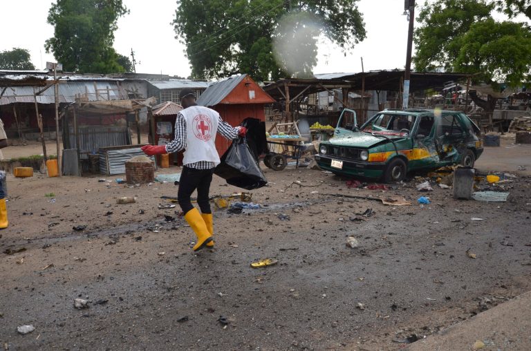 A red cross official walks at the site of a bomb explosion in Maiduguri, Nigeria, Friday, July 31, 2015. (AP Photo/Jossy Ola)