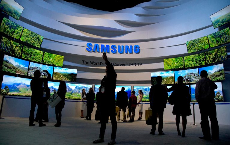 FILE - In this Thursday, Jan. 9, 2014, file photo, trade show attendees take in a display of Samsung curved UHD TVs at the International Consumer Electronics Show, in Las Vegas.  Samsung reports quarterly earnings on Friday, Jan. 24, 2014.(AP Photo/Julie Jacobson, File)