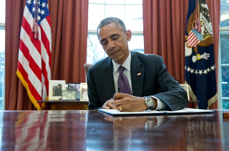 President Barack Obama signs a presidential memorandum on paid leave in the Oval Office of the White House in Washington. (AP/Carolyn Kaster)