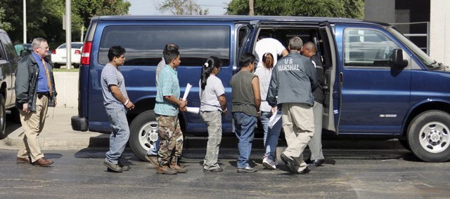 U.S. Marshal deputies direct several suspected illegal immigrants from the federal courthouse Tuesday in Hattiesburg, Miss., to a waiting van for transportation to an overnight holding facility in 2008. (AP Photo)