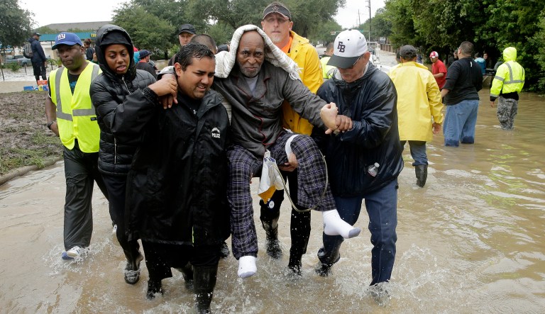 It's cynical to use the cover of emergency response to fund other priorities. Here, an elderly man is carried to dry ground as he evacuates a neighborhood in west Houston inundated by floodwaters on Tuesday. (AP Photo/Charlie Riedel)