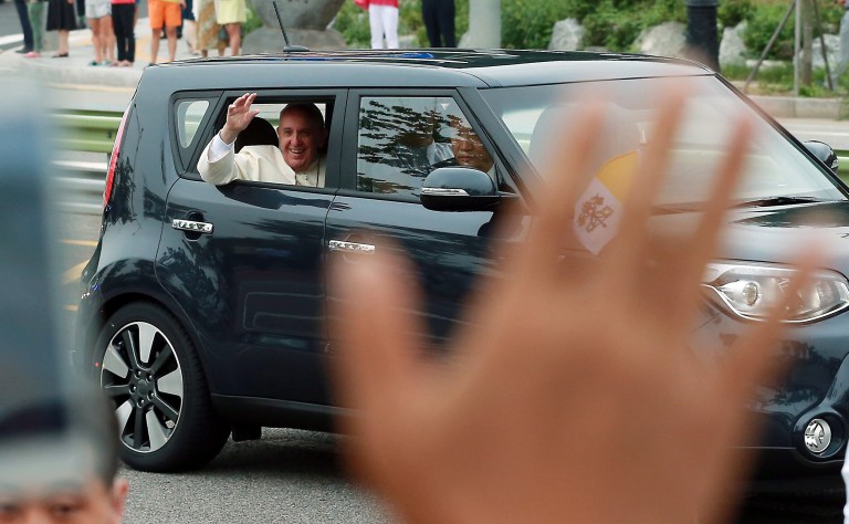 Pope Francis waves from a car after his arrival in Seongnam, south of Seoul, South Korea, Thursday, Aug. 14, 2014. As Francis became the first pope in 25 years to visit South Korea on Thursday, Seoul's never-timid rival, North Korea, made its presence felt by firing three short-range projectiles less than an hour before he arrived, officials said. (AP Photo/Yonhap, Shin Jun-hee) KOREA OUT