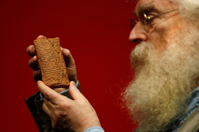 Irving Finkel, curator in charge of cuneiform clay tablets at the British Museum, poses with the 4000 year old clay tablet containing the story of the Ark and the flood during the launch of his book 'The Ark Before Noah' at the British Museum in London, Friday Jan. 24, 2014. The book tells how he decoded the story of the Flood and offers a new understanding of the Old Testament's central narratives and how the flood story entered into it. (AP Photo/Sang Tan)