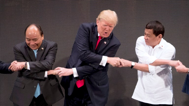 U.S. President Donald Trump, center, reacts as he does the 