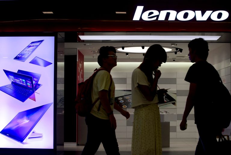 FILE - In this Aug. 15, 2013 file photo, people walk past a Lenovo flagship experience store in Beijing, China. Lenovo Group has received U.S. and European approval to complete its acquisition of IBM Corp.'s low-end server business and plans to use it to grow faster outside its personal computer business, Lenovo's chairman said Monday, Sept. 29, 2014. (AP Photo/Andy Wong, File)