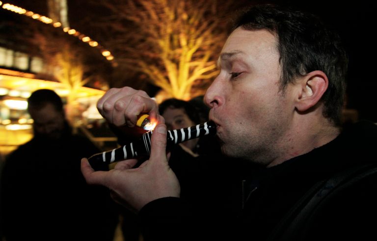   Gary Parrish smokes marijuana in a glass pipe, Thursday, Dec. 6, 2012, just after midnight at the Space Needle in Seattle. Possession of marijuana became legal in Washington state at midnight, and several hundred people gathered at the Space Needle to smoke and celebrate the occasion, even though the new law does prohibit public use of marijuana. (AP Photo/Ted S. Warren)  
