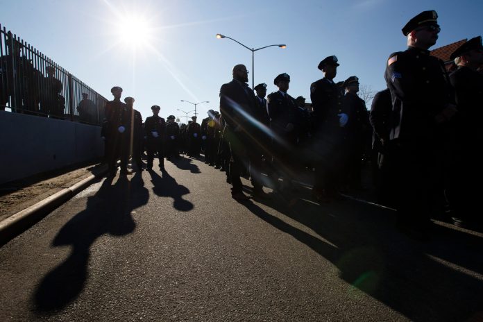 Police officers turn their backs as New York City Mayor Bill de Blasio speaks at the funeral of New York city police officer Rafael Ramos in the Glendale section of Queens, Saturday, Dec. 27, 2014, in New York. (AP Photo/John Minchillo)