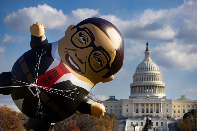 A 15-foot inflatable George Santos tumbles in gusty winds on the National Mall in Washington during MoveOn Political Action's event to call on the House to expel Rep. George Santos (R-NY) on Tuesday, Nov. 28, 2023.