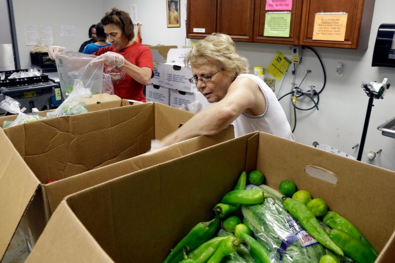 In this Sept. 13, 2013, photo, volunteerspack food to be distributed at the Catholic Parish Outreach Food Pantry in Raleigh, N.C. North Carolinaâs food banks are struggling to serve huge numbers of hungry people as problems with a new state computer system, NC FAST, have delayed processing of food stamp applications. (AP Photo/Gerry Broome)