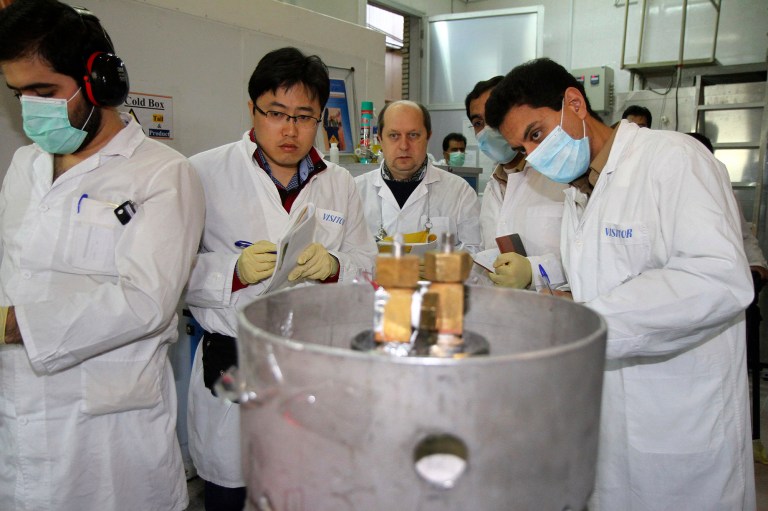 Unidentified International Atomic Energy Agency inspectors and Iranian technicians are on hand to cut the connections between the twin cascades for 20 percent uranium enrichment at Natanz facility, some 200 miles south of the capital Tehran, Iran, Monday, Jan. 20, 2014. (AP Photo/IRNA, Kazem Ghane)