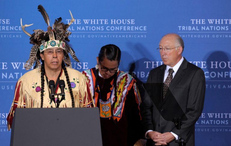 Onondaga Nation leader Tadodaho Sidney Hill, left, accompanied by Jamon Paskernin, center, and Interior Secretary Ken Salazar, gives the invocation at the 2012 Tribal Nations Conference, December 2012, at the Interior Department in Washington. (AP/Susan Walsh)