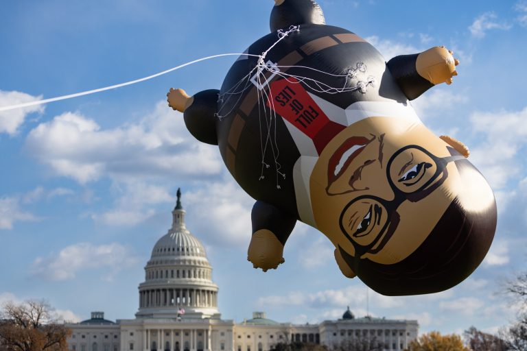 Activists with the advocacy group MoveOn display a 15-foot inflatable of Rep. George Santos (R-NY) on the National Mall on Tuesday, Nov. 28, 2023. A House Ethics report in Santos found substantial evidence of fraud and ethics violations. On Friday the House voted to expel Santos from Congress. He is the sixth lawmaker ever to be expelled from the House.