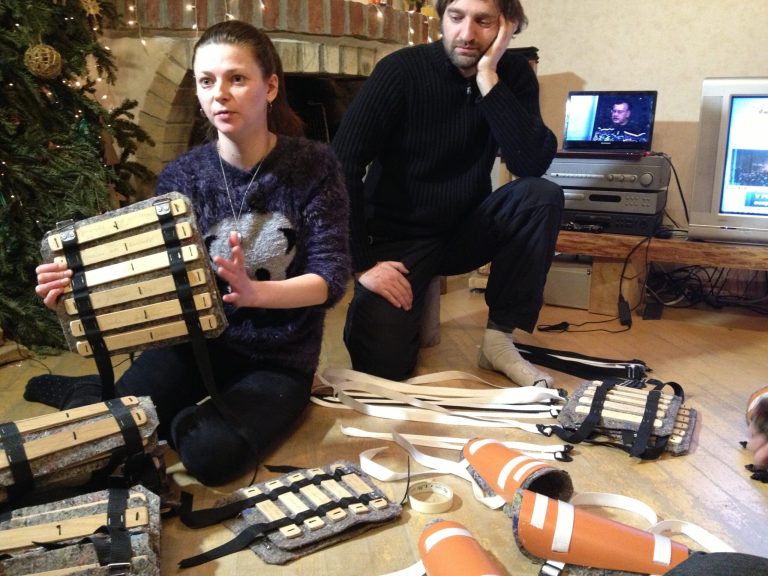 In this Saturday, Jan. 25, 2014 photo Marianna Kvyatkovska, left, and Alexander Bitkin fashion homemade shin and elbow pads from plastic drainage pipes at their home in Lviv, a city in Western Ukraine, which they will send to friends who are camped out in anti-government demonstrations in Kiev. Young artistic designers stayed up very late on a recent night working on their pet project _ not a chic gallery opening, but battle armor for protesters. (AP Photo/ Laura Mills)