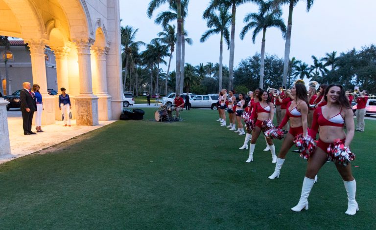 President Donald Trump and first lady Melania view the Florida Atlantic University Marching Band and cheerleaders at Trump International Golf Club in West Palm Beach, Fla., Sunday, Feb. 4, 2018, as they arrive for a Super Bowl party. (AP Photo/Carolyn Kaster)