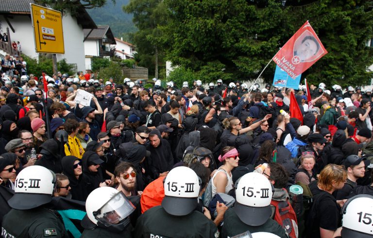 Police stand beside demonstrators during a protest march in Garmisch-Partenkirchen, southern Germany, Saturday, June 6, 2015 against the G-7 summit in nearby Schloss Elmau hotel on June 7/8. (AP Photo/Markus Schreiber)