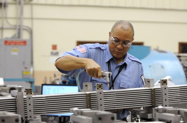 In this July 30, 2014 photo, flexible fuel operator John Lewis sprays air on tubes that make up the fuel bundle assembly at the GE Hitachi plant in Castle Hayne, N.C. The Commerce Department reports on business inventories for July on Friday, Sept. 12, 2014. (AP Photo/The Star-News, Mike Spencer)