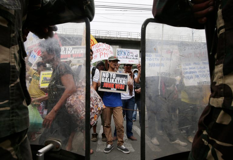 Protesters shout slogans as they picket the headquarters of the Armed Forces of the Philippines to coincide with the opening ceremony of the joint U.S.-Philippines military exercise dubbed Balikatan 2014, Monday, May 5, 2014 at suburban Quezon city, northeast of Manila, Philippines. More than 5,000 U.S. and Filipino troops have begun two weeks of military exercises to flex their muscle in jointly dealing with potential crisis in the Philippines, which is prone to natural disasters and has been locked in a dangerous standoff with China over a disputed shoal. This year's war games focuses on maritime security. (AP Photo/Bullit Marquez)