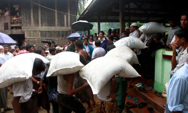   Muslims unload rice sacks to their refugee camp at a village in Sittwe, capital of Rakhine state in western Myanmar on Thursday, June. 14, 2012. Heavy rain Wednesday brought an uneasy calm to western Myanmar after five days of deadly sectarian strife, though residents said they were too afraid to sleep at night and faced food shortages. (AP Photo/Khin Maung Win)  