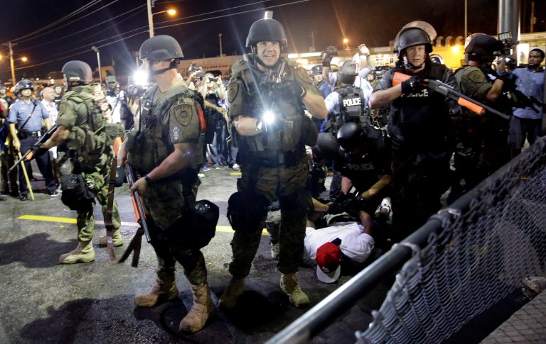 A man is arrested as police try to disperse a crowd during protests in Ferguson, Mo. early Wednesday, Aug. 20, 2014. On Saturday, Aug. 9, 2014, a white police officer fatally shot Michael Brown, an unarmed black 18-year old, in the St. Louis suburb. (AP Photo/Jeff Roberson)