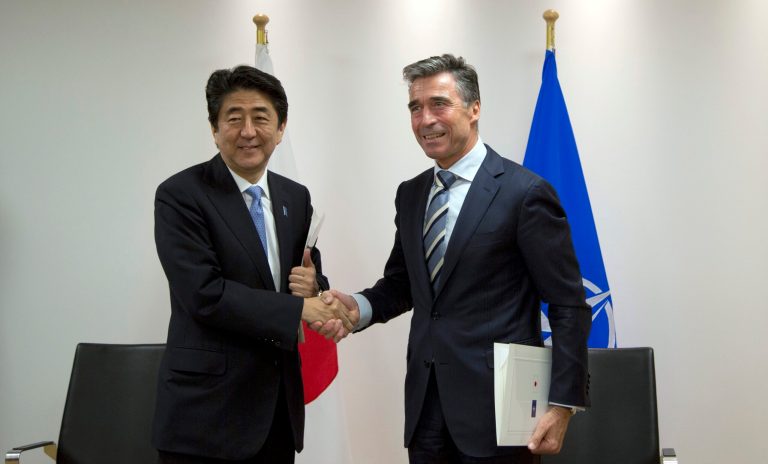 Japan's Prime Minister Shinzo Abe, left, and NATO Secretary General Anders Fogh Rasmussen, right, shake hands after signing a cooperation agreement at NATO headquarters in Brussels on Tuesday, May 6, 2014. Abe will, in a two-day visit, meet with NATO, EU and Belgian officials. (AP Photo/Virginia Mayo, Pool)