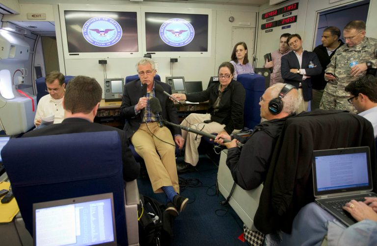 U.S. Defense Secretary Chuck Hagel, center, is seen aboard a U.S. Military Aircraft before speaking to members of the media during his flight, Sunday, June 1, 2014. Hagel spoke about the released of U.S. Army Sgt. Bowe Bergdahl who was held hostage in Afghanistan, and who was handed over Saturday morning by members of the Taliban in exchange for five Afghan detainees held at the military prison in Guantanamo Bay prison in Cuba. (AP Photo/Pablo Martinez Monsivais, Pool)