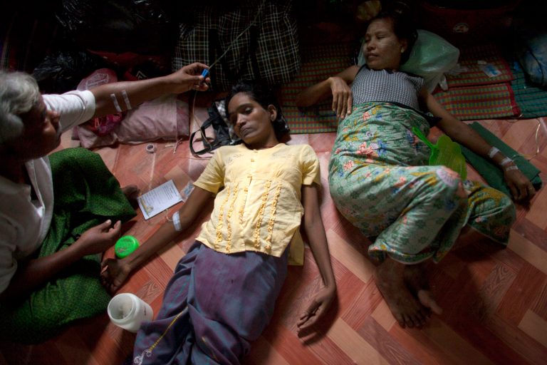   In this Sept. 1, 2012 photo, an HIV-infected woman, center, receives medication through an intravenous drip after she fainted, as another HIV patient, right, is also treated in a hut shared with other HIV patients at an HIV/AIDS hospice on the outskirts of Yangon, Myanmar. According to UNAIDS, AIDS kills an estimated 18,000 people a year in Myanmar. The country is one of the hardest places in the world to receive HIV treatment. Myanmar spent less than $1 per person on health in 2008, minus donor money, and ranks among the lowest countries in nearly every category of health care funding. Now, with the dramatic change that has given Myanmar an elected government, there are hopes for improvement, but the country faces a long climb. (AP Photo/Alexander F. Yuan)  