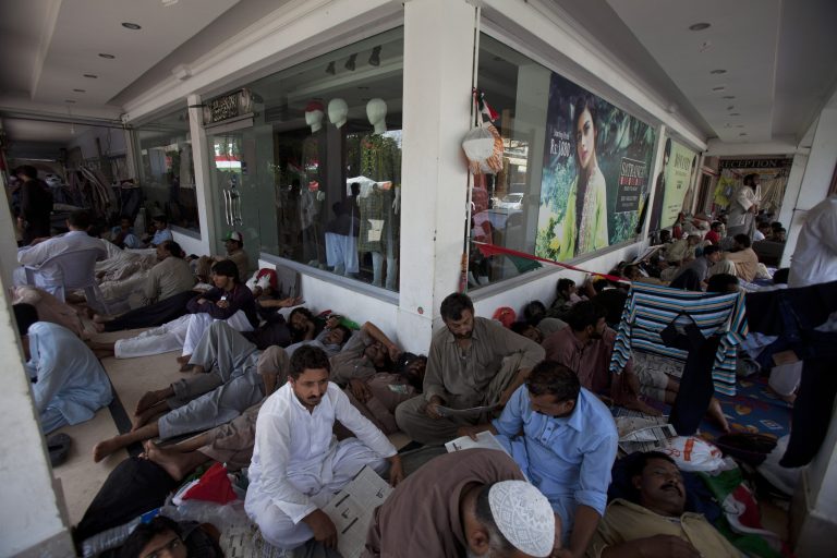 Supporters of Pakistan's fiery anti-government cleric Tahir-ul-Qadri block a corridor to rest in a closed main business hub of Islamabad, Pakistan, Monday, Aug. 18, 2014. Twin protests demanding the Pakistani government step down have wreaked havoc in the capital, Islamabad, where commuters must circumvent shipping containers and barbed wire to get to work, protesters knock on people's doors to use the bathroom, and garbage is piling up. (AP Photo/B.K. Bangash)