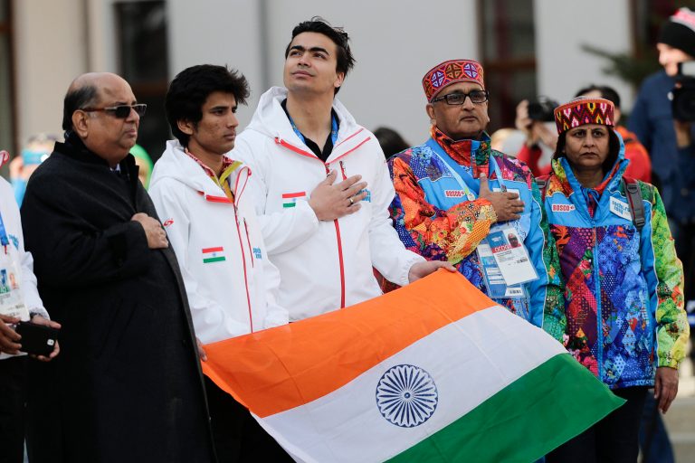 Newly elected Indian Olympic Association President Narayna Ramachandran, left, and members of the Indian Olympic team, alpine skier Thakur Himanshu, second left, and luger Shiva Keshavan, center, listen to the Indian national anthem during a welcome ceremony at the Mountain Olympic Village on Sunday, Feb. 16, 2014, during the 2014 Winter Olympics in Krasnaya Polyana, Russia. (AP Photo/Jae C. Hong)