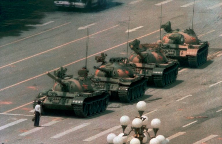 A Chinese man stands alone to block a line of tanks heading east on Beijing's Cangan Boulevard in Tiananmen Square on June 5, 1989. The man, calling for an end to the recent violence and bloodshed against pro-democracy demonstrators, was pulled away by bystanders, and the tanks continued on their way. The Chinese government crushed a student-led demonstration for democratic reform and against government corruption, killing hundreds, or perhaps thousands of demonstrators in the strongest anti-government protest since the 1949 revolution. Ironically, the name Tiananmen means 