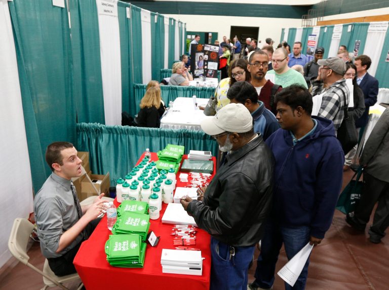 In this April 22, 2014 photo, Bryan Preston of Hannaford supermarkets, left, talks with job seekers during a job fair at Columbia-Greene Community College in Hudson, N.Y. The Labor Department reports the number of people who applied for unemployment benefits last week on Thursday, May 8, 2014. (AP Photo/Mike Groll)