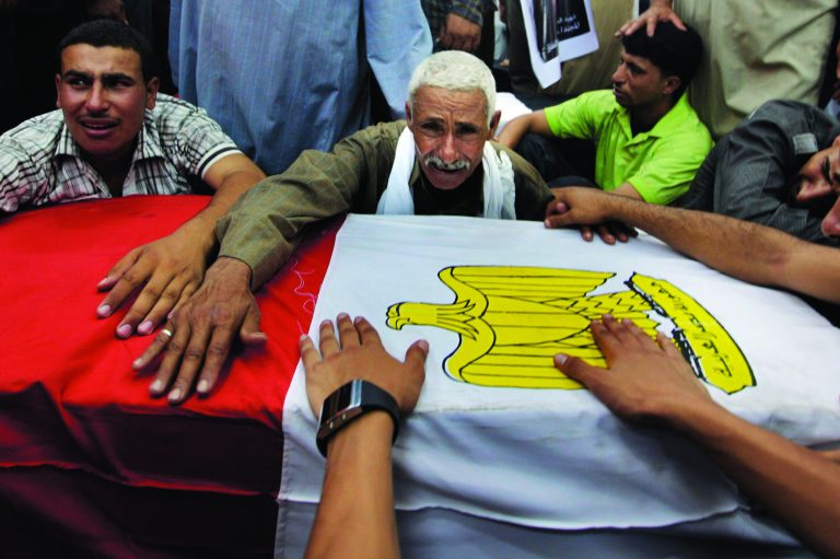 FILE - In this Tuesday Aug. 7, 2012 file photograph, relatives of an Egyptian soldier mourn during the funeral of one of 16 soldiers killed in an attack over the weekend by suspected militants in Sinai in Cairo, Egypt. After decades of neglect and with the collapse of government authority the past 18 months, Egypt's Sinai Peninsula has become fertile ground for Islamic extremists. Militant groups have taken root, carrying out attacks against neighboring Israel and now turning their guns against Egypt's military as they vow to set up an Islamic state. (AP Photo/Amr Nabil, File)