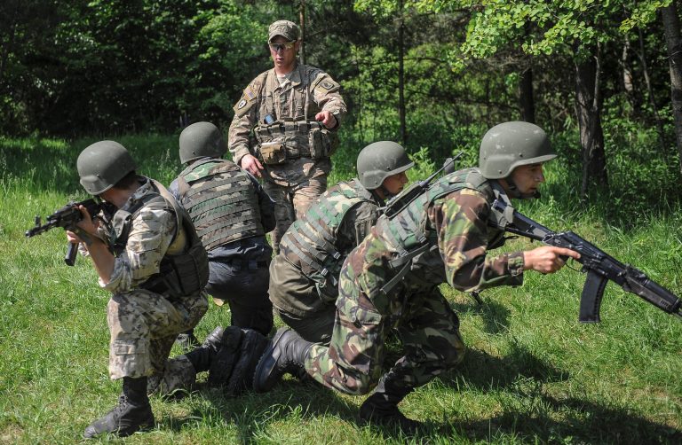 US soldier, center, instructs Ukrainian soldiers during joint training exercises on the military base in the Lviv region, western Ukraine, Wednesday, June 3, 2015. Troops from the United States and Ukraine conduct joint training exercises intended to help bolster Ukraine's defense against incursions from Russian-backed separatists. (AP Photo/Andrew Kravchenko, Pool)