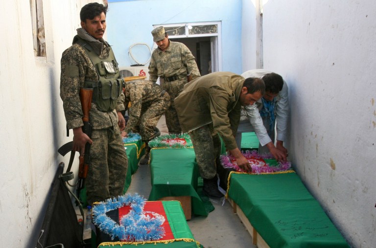 Afghan Army soldiers prepare the coffins for their killed comrades in the morgue of the main hospital in Ghazni, Afghanistan, Wednesday, April 17, 2013. A roadside bomb killed the five soldiers who were part of a government security force guarding a convoy of trucks in Ghazni's Qarabagh district. Roadside bombs and insurgent attacks killed dozens of people in five separate attacks across Afghanistan as violence steadily rises during this year's spring fighting season, officials said Wednesday. (AP Photo/Rahmatullah Nikzad)