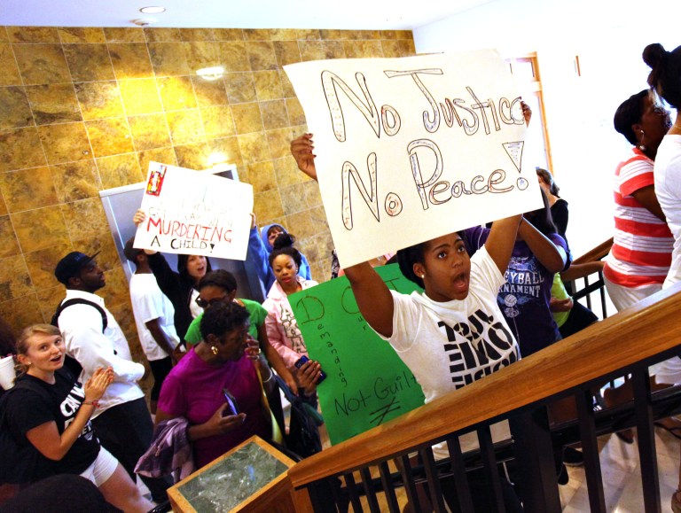 People from the local community, members of the Dream Defenders at University of Florida and other social groups march up the stairs to the local Department of Justice office in the Commerce Building, after a march from the Bo Diddley Downtown Community Plaza to the Department of Justice, Monday, July 15, demanding that the Justice Department file charges against George Zimmerman. (AP/The Gainesville Sun, Brad McClenny)