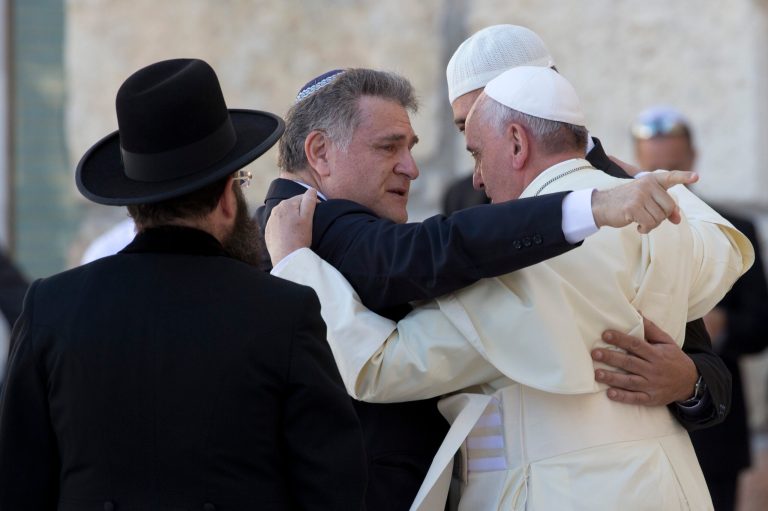 Pope Francis embraces two good friends of his traveling with him, Argentine Rabbi Abraham Skorka, center, and Omar Abboud, leader of Argentina's Muslim community, partially seen next to the Pope, after praying at the Western Wall in Jerusalem's Old City, Israel, Monday, May 26, 2014. At left with back to camera is Rabbi of the Western Wall Shmuel Rabinovitch. (AP Photo/Andrew Medichini, Pool)