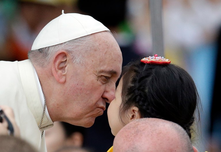 Pope Francis, kisses a child upon arrival for the Closing Holy Mass of the 6th Asian Youth Day at Haemi Castle in Haemi, south of Seoul, South Korea, Sunday, Aug. 17, 2014. (AP Photo/Lee Jin-man, Pool)