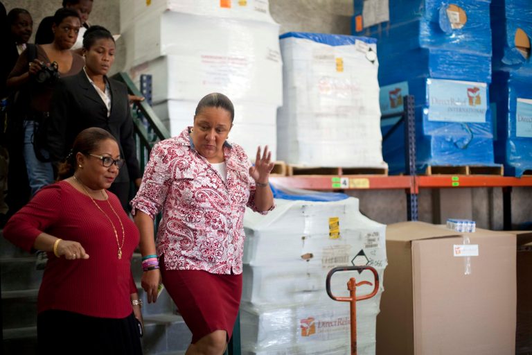 Haiti's Health Minister Florence Duperval Guillaume, left, leads a tour for first lady Sophia Martelly through a warehouse housing a donation of kits to treat chikungunya, in the Cite Soleil slum, in Port-au-Prince, Haiti, Wednesday, Sept. 10, 2014. The U.S. medical aid group Direct Relief donated millions of kits to treat the mosquito-borne virus that has sickened tens of thousands across the Caribbean over the past year. (AP Photo/Dieu Nalio Chery)