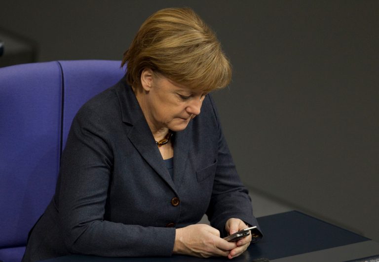German Chancellor Angela Merkel uses her mobile phone at the German Federal Parliament Bundestag in Berlin. (AP/Gero Breloer)