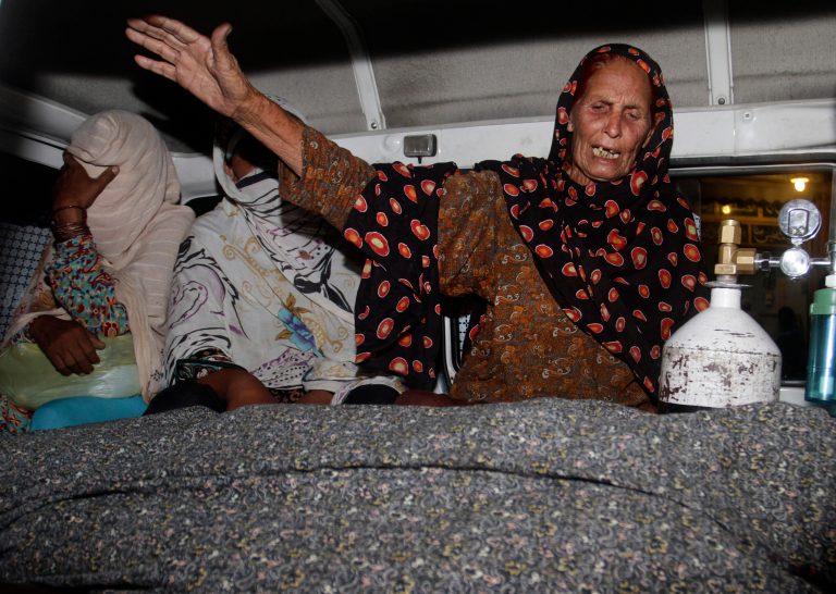 A family member of a pregnant woman who was stoned to death by here own family wails over her dead body in an ambulance at a local hospital in Lahore, Pakistan, Tuesday, May 27, 2014. Nearly 20 members of the woman's family, including her father and brothers, attacked her and her husband with batons and bricks in broad daylight before a crowd of onlookers in front of the high court of Lahore, police investigator Rana Mujahid said. (AP Photo/K.M. Chaudary)