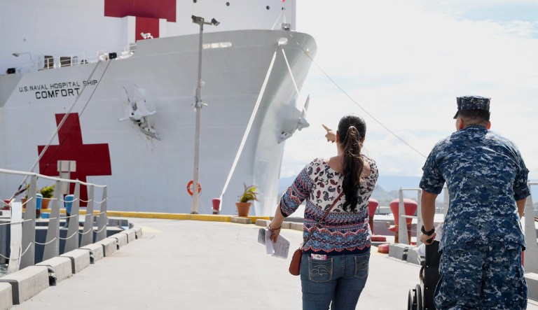 A sailor escorts patients to receive care aboard the Military Sealift Command hospital ship USNS Comfort.