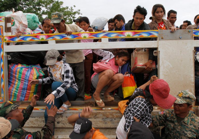 Cambodian migrant workers get off a Thai truck upon their arrival from Thailand at a Cambodia-Thailand's international border gate in Poipet, Cambodia, Tuesday, June 17, 2014. The number of Cambodians who have returned home from Thailand this month after a threatened crackdown on foreigners working illegally has topped 160,000, a Cambodian official said Monday. Thai officials insist the cross-border movement is voluntary and is not forced repatriation. They say Thai military and government resources were used to transport workers who decided to return home after being laid off because they were working illegally. (AP Photo/Heng Sinith)