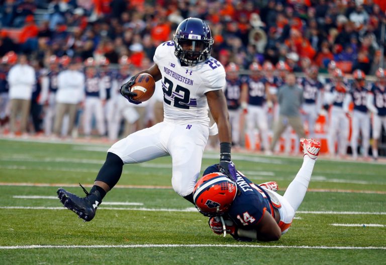 Northwestern running back Treyvon Green is brought down by Illinois safety Eric Finney during the first half of an NCAA college football game on Nov. 30 in Champaign, Ill. (AP Photo/Jeff Haynes)
