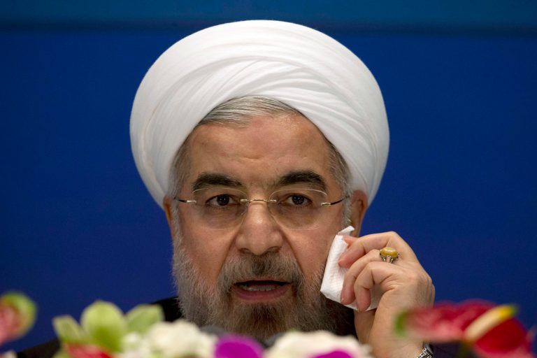 Iranian President Hassan Rouhani wipes his cheek as he speaks during a press conference at a hotel in Shanghai, China, Thursday, May 22, 2014. Rouhani says an agreement on curbing its nuclear program is 
