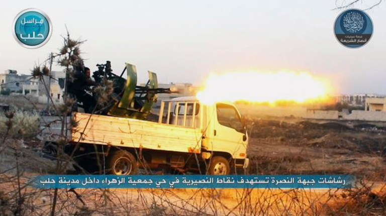 In this file image posted on a Twitter account of Syria's al-Qaida-linked Nusra Front on early Tuesday, July 7, 2015, a fighter from the Nusra Front fires a weapon during clashes against the Syrian government forces. (Al-Nusra Front via AP, File)